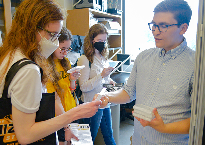 Student receiving information during a tour of a Plant Science & Technology lab.