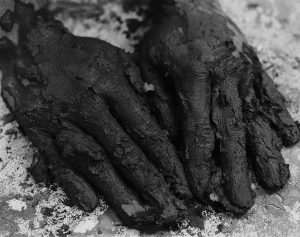 A pair of muddy hands on a tabletop